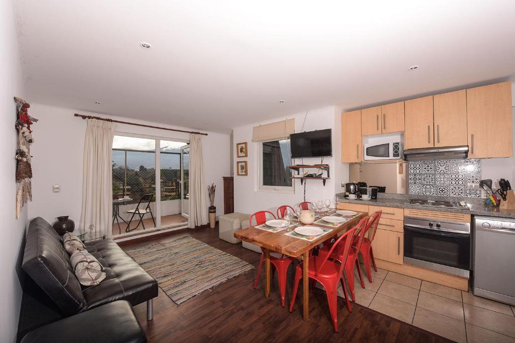 a kitchen and living room with a table and chairs at Pucón in Pucón