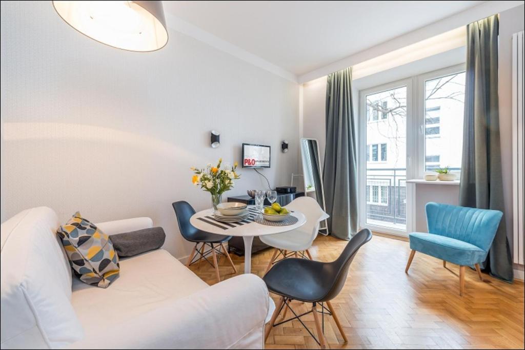 a living room with a white couch and a table at P&O Apartments Poznańska in Warsaw