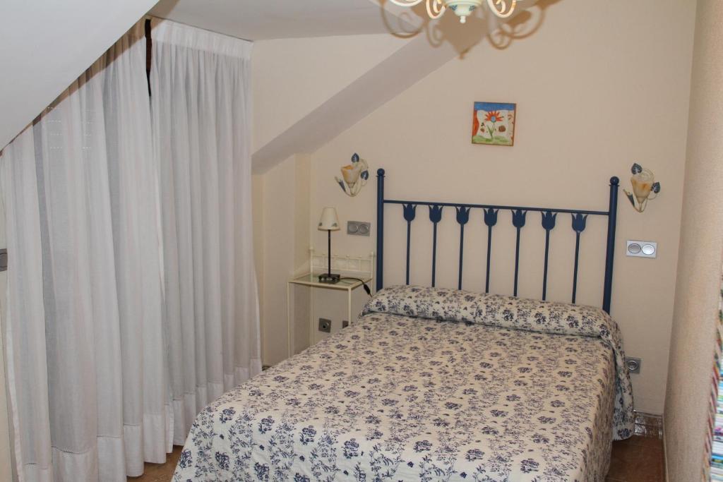 a bedroom with a bed with a bedspread on it at Apartamentos Costa Noja in Noja