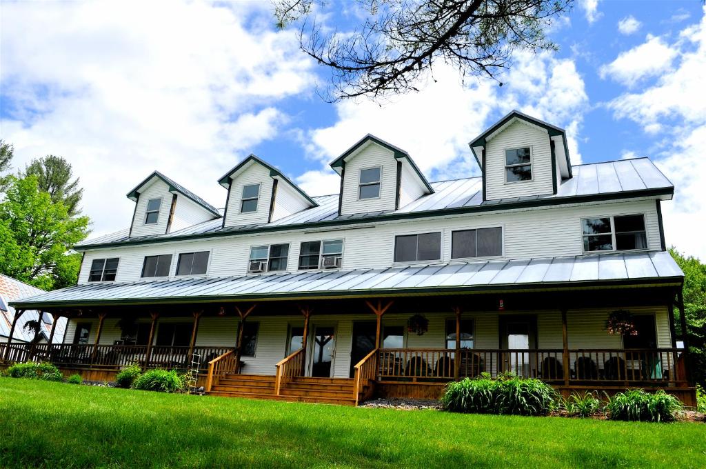 een groot wit huis met een gambrel dak bij Inn by the River in The Forks