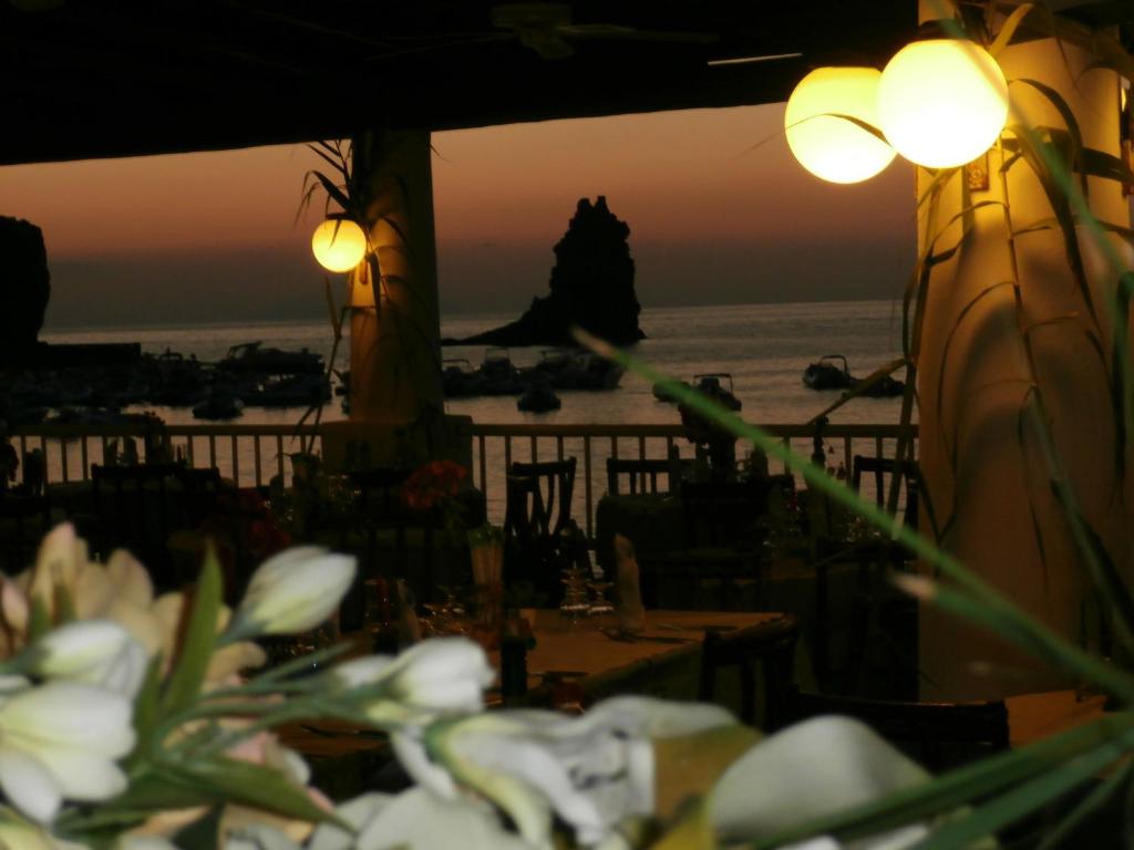 einen Blick auf das Meer von einem Restaurant mit Blumen in der Unterkunft Hotel Conti in Vulcano