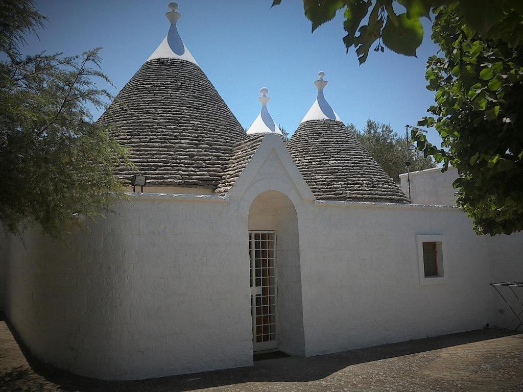 Un bâtiment blanc avec deux tours en haut dans l'établissement Trullocarluccio, à Monopoli