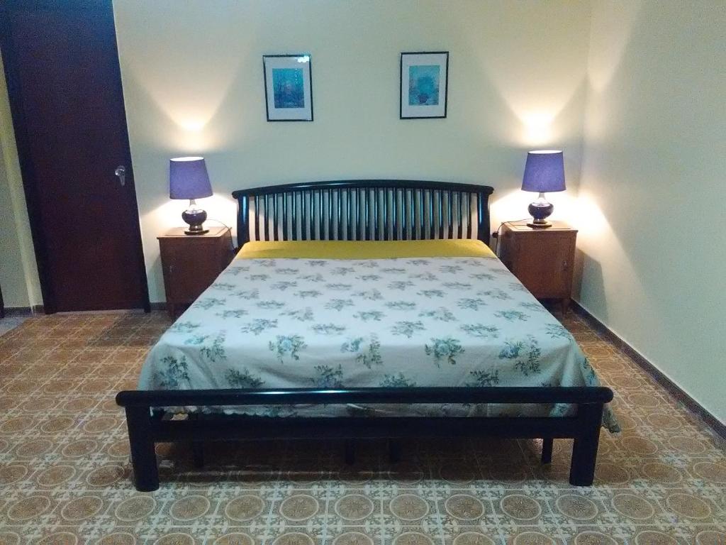 Casa Skanderbek في شيفيتا: غرفة نوم مع سرير مع مصباحين على الطاولات