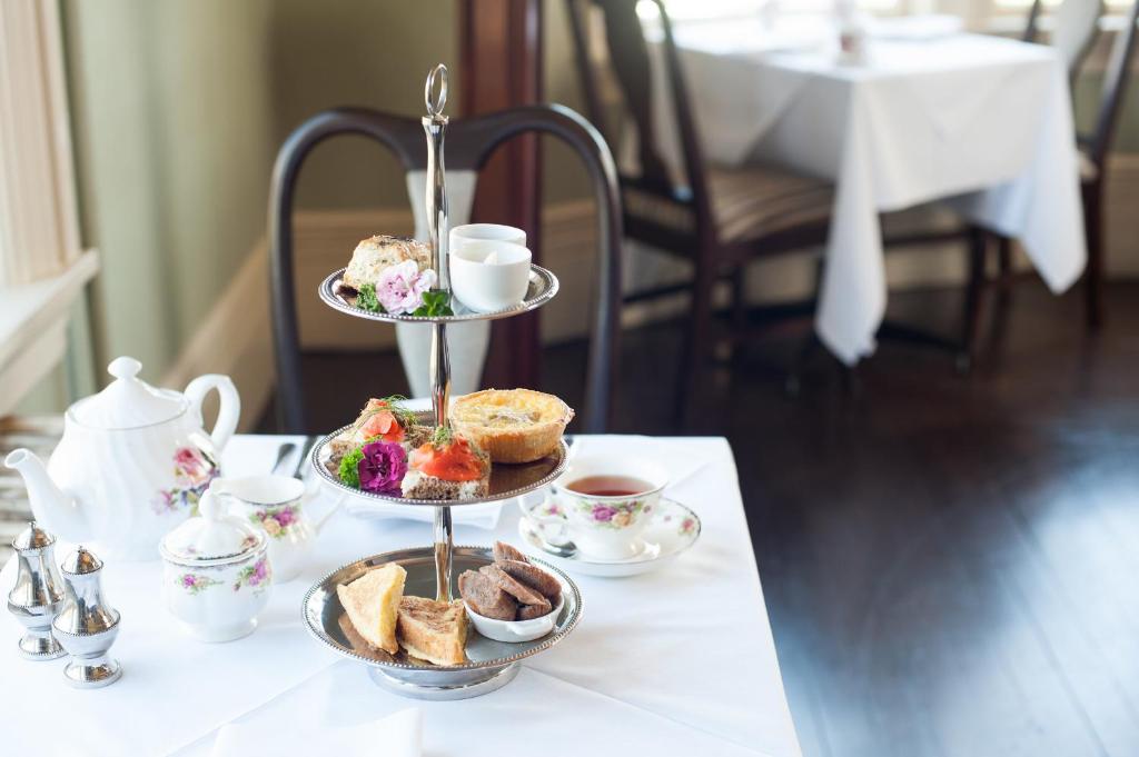 a three tiered tray of pastries and tea cups on a table at Pendray Inn and Tea House in Victoria