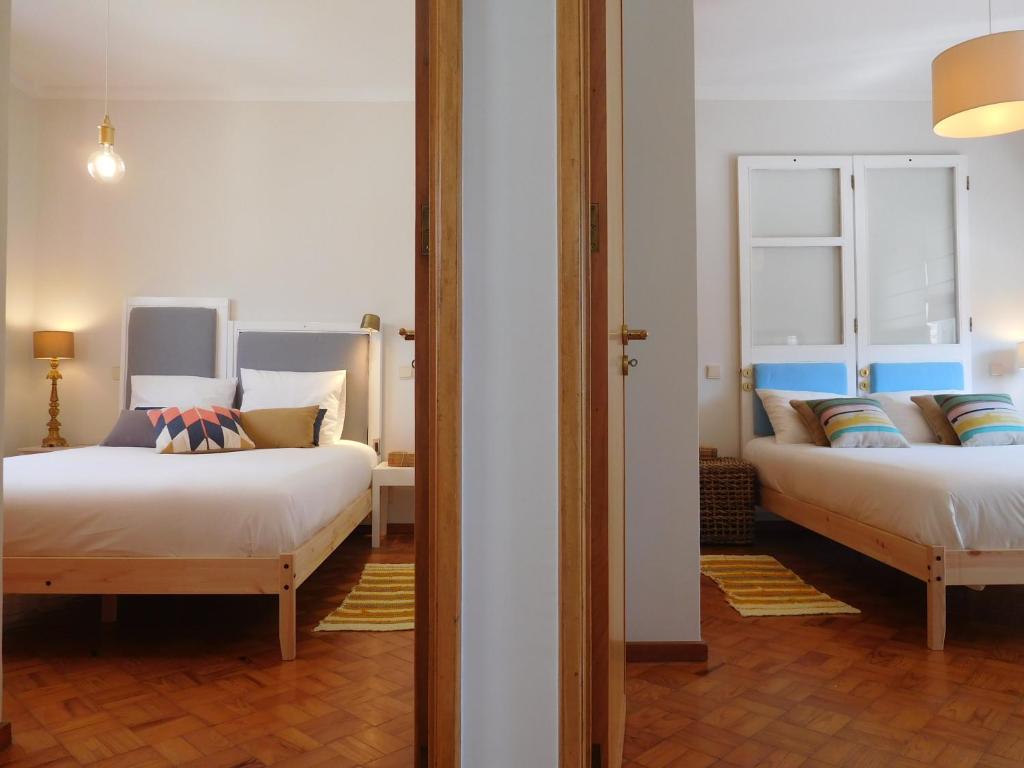 a bedroom with two beds and a mirror at Family House in Vila Nova de Gaia