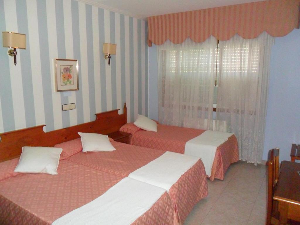 Habitación de hotel con 2 camas y ventana en Hotel Vimar, en Sanxenxo