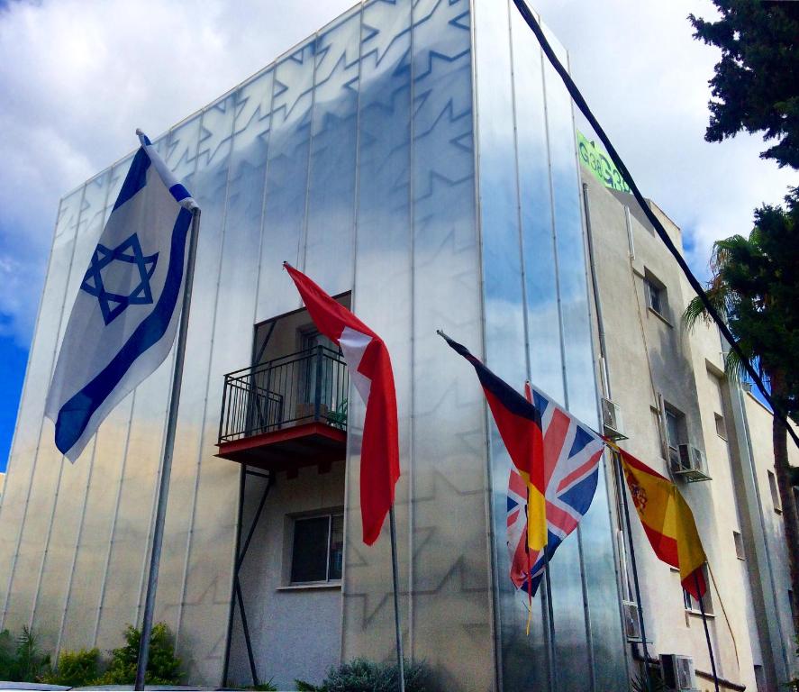 three flags are on the side of a building at G38 Rental Apartment Building in Haifa