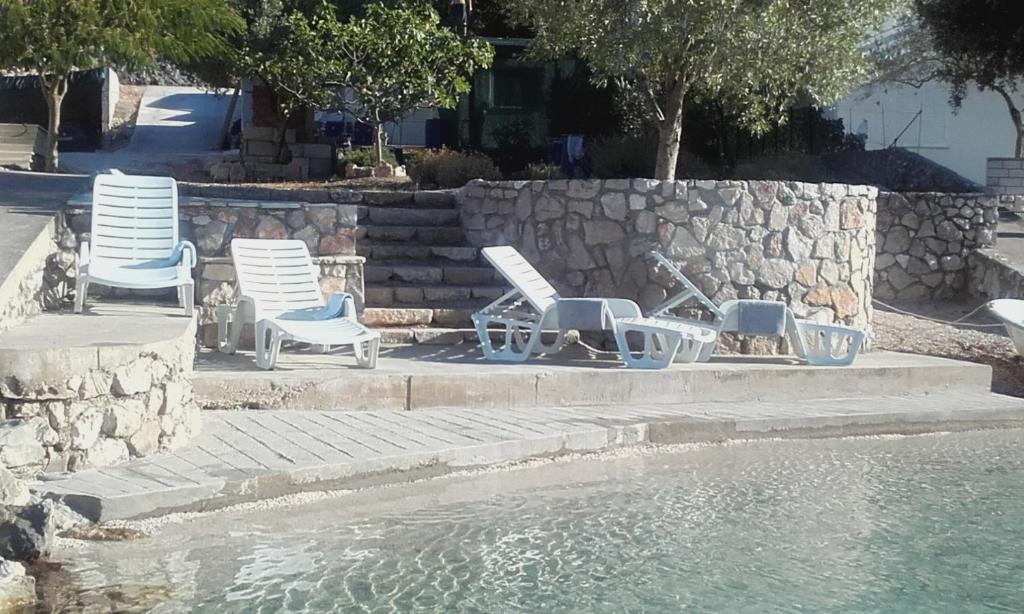 un grupo de sillas sentadas junto a una piscina de agua en Kuća za odmor >Maro< en Ston