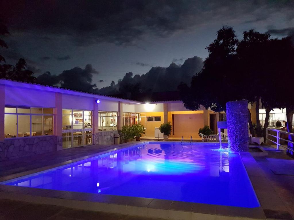 a swimming pool in front of a house at night at Hotel Brotas in Afogados da Ingàzeira