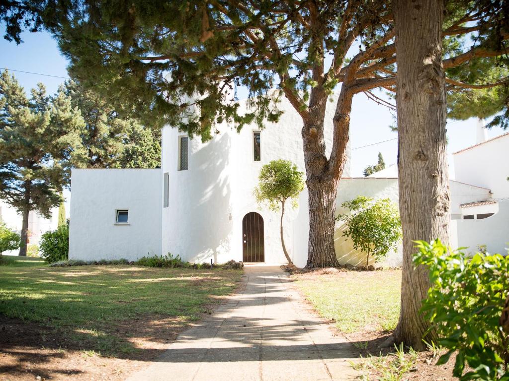 a white building with a tree in front of it at Vivenda Jardim Mar Algarve Porches in Porches
