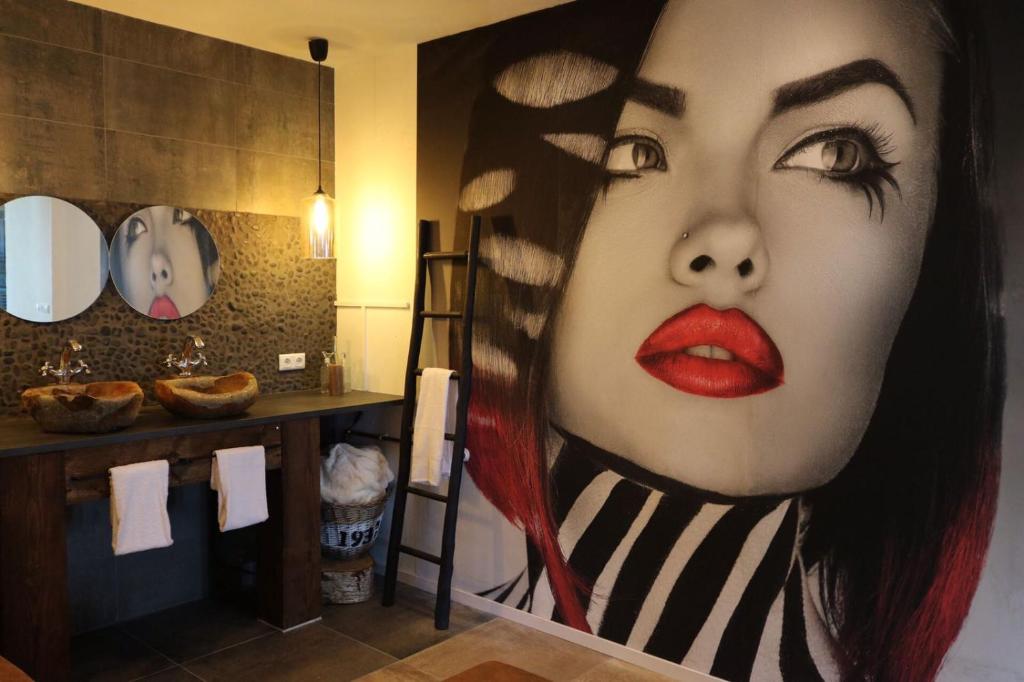 a bathroom with a painting of a woman with red lipstick at Byonz in Groningen