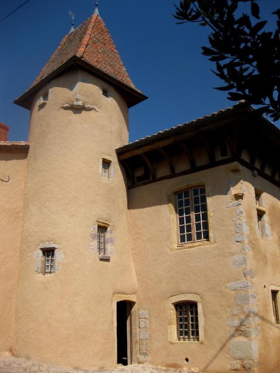 un bâtiment avec une tour sur son côté dans l'établissement Manoir au sein du village, à Saint-Haon-le-Châtel