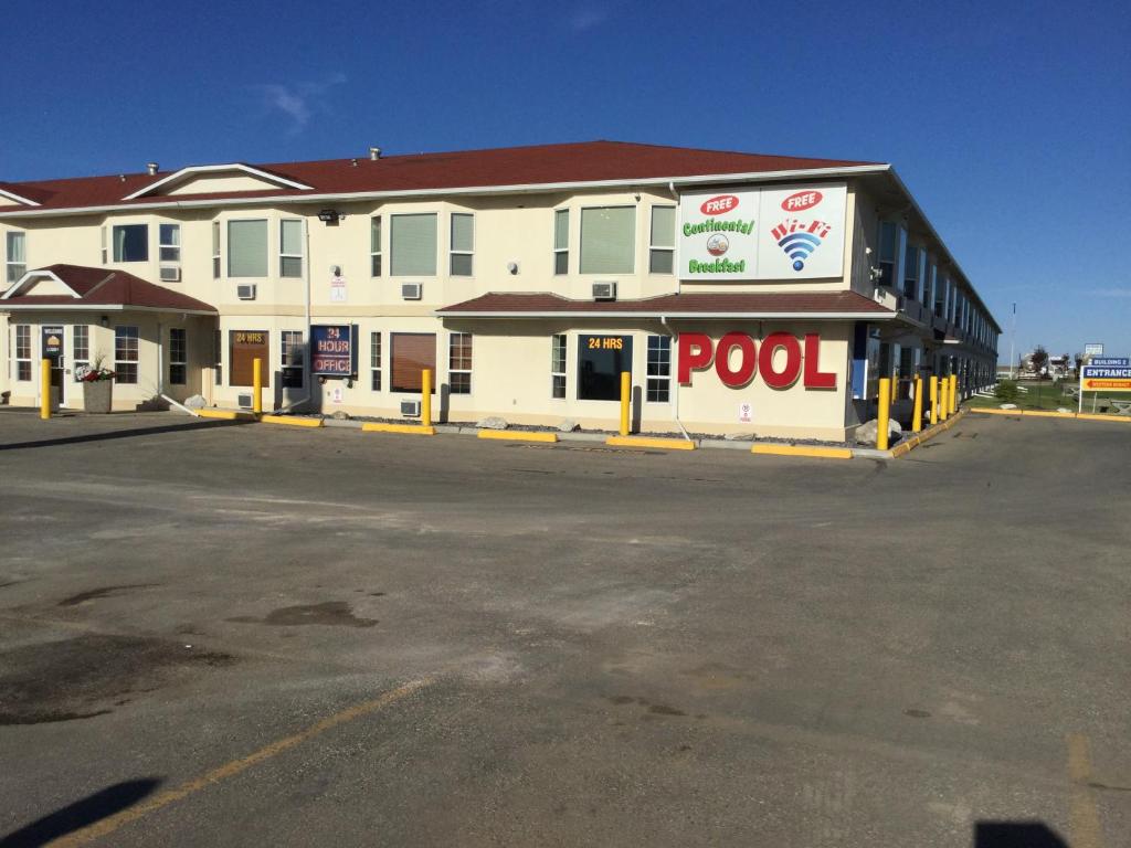 a building with a pool sign in a parking lot at Western Budget Motel #2 Grande Prairie in Grande Prairie