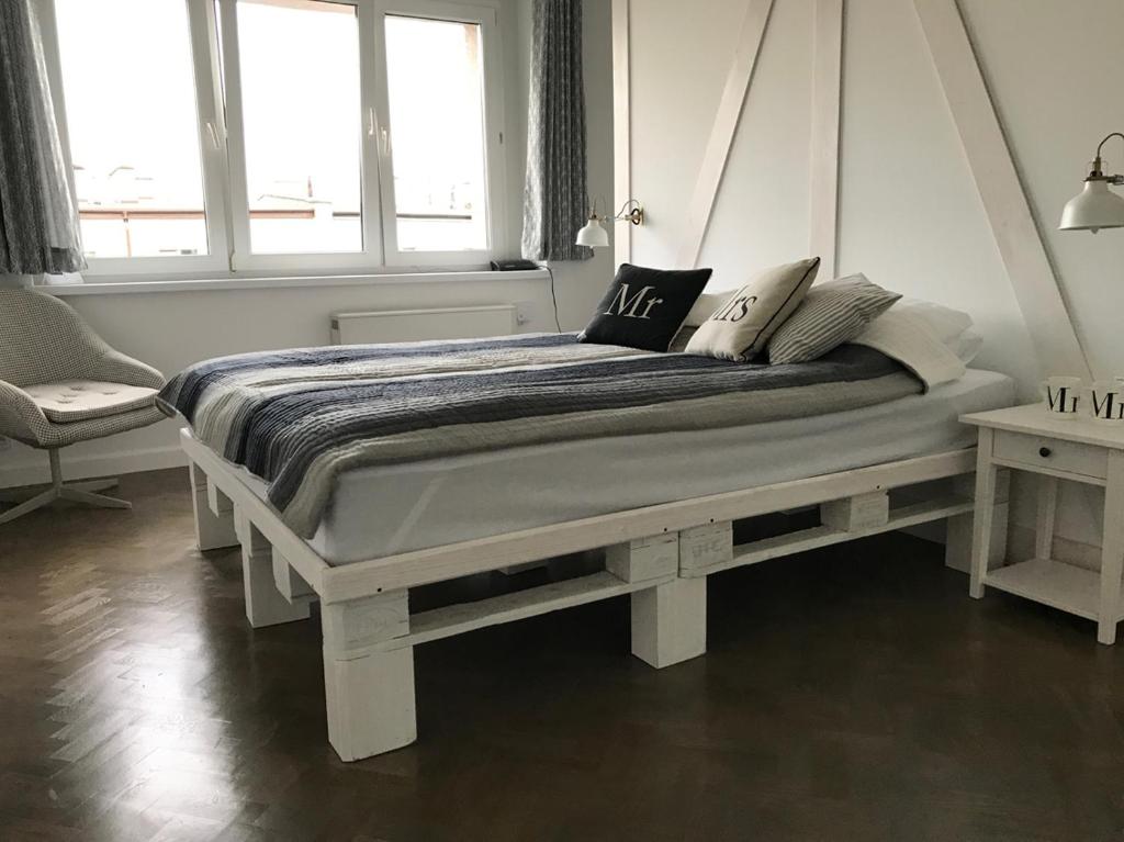 een wit bed in een kamer met 2 ramen bij Apartament Prusa No 9 in Toruń