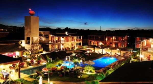 a view of a resort with a swimming pool at night at Suites Pipa Beleza Spa Resort in Pipa