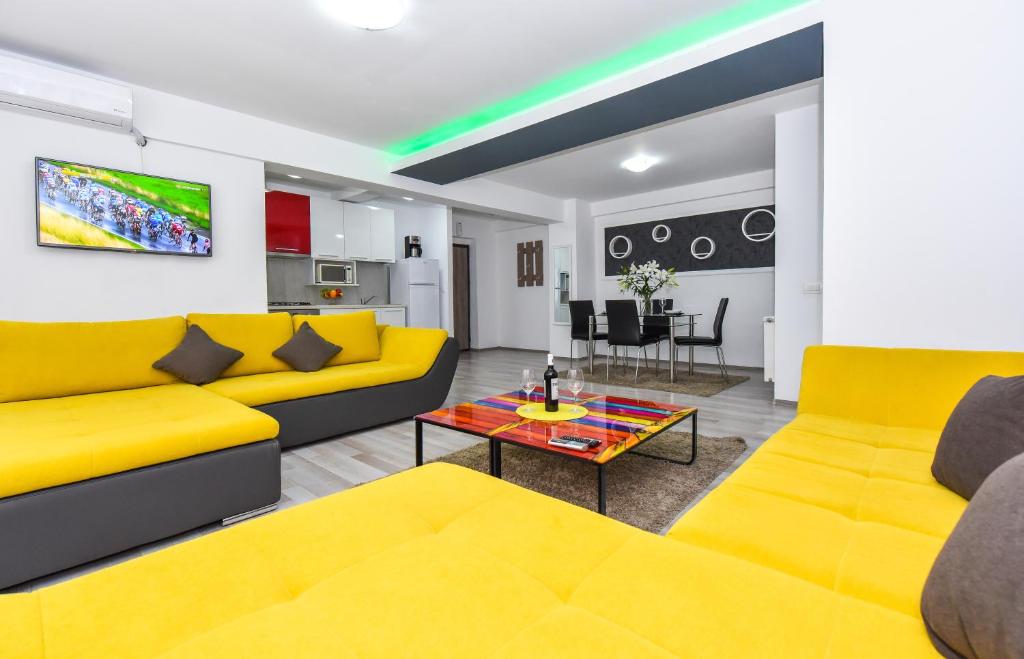 sala de estar con sofás amarillos y mesa en Bucharest Old Town Apartments, en Bucarest