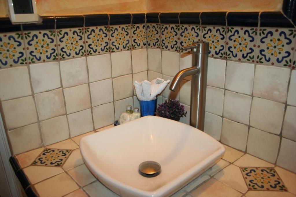 a white sink in a bathroom with a tap at Hotel Ciudad Vieja in Guatemala
