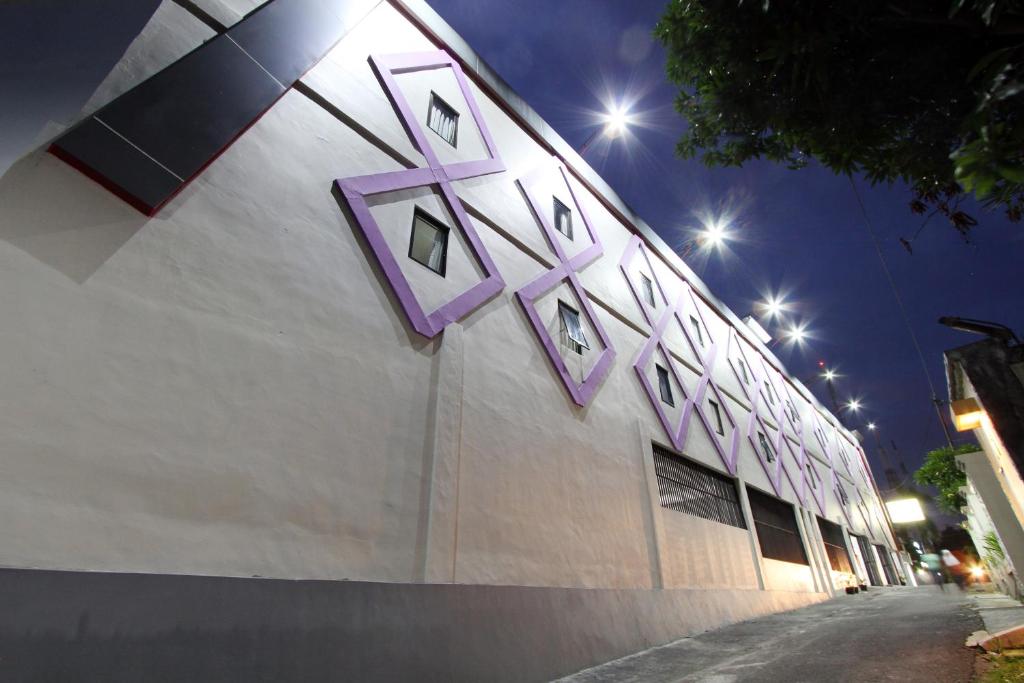 un bâtiment avec un panneau violet sur son côté dans l'établissement D'Paragon Bukit Sari, à Semarang