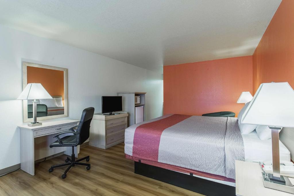 Una habitación de hotel con una cama y un escritorio con una computadora. en Motel 6-Lordsburg, NM, en Lordsburg