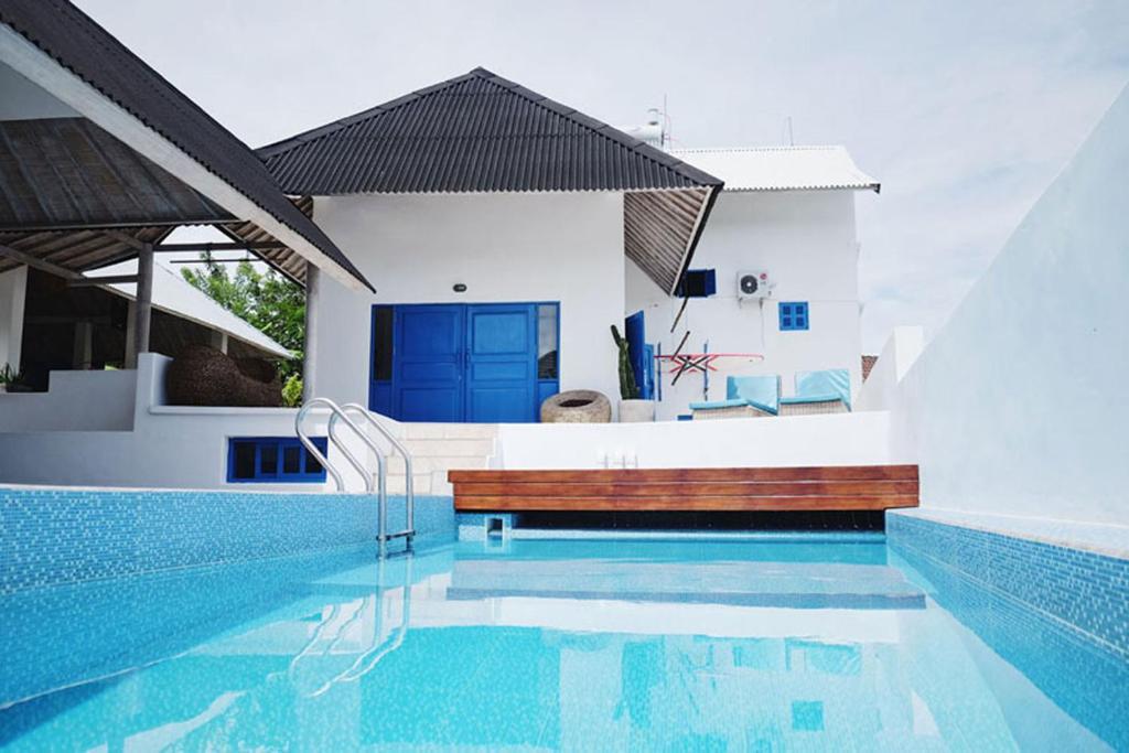 a swimming pool in front of a house at Bali Bio Villas in Uluwatu