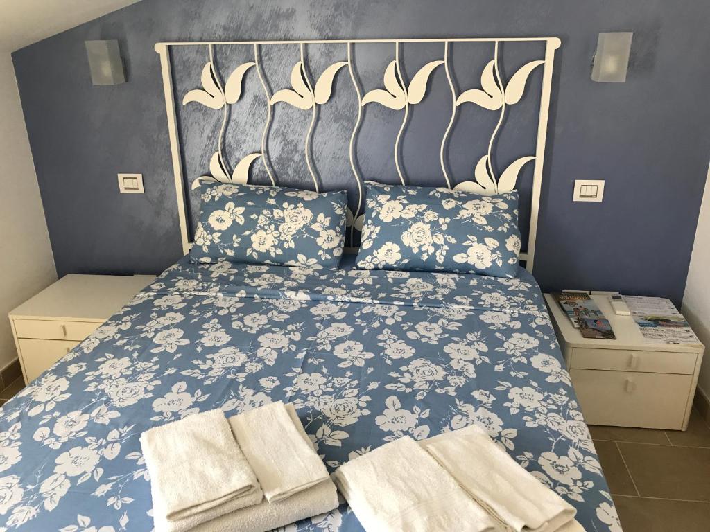 ヴァストにあるCasa Sul Mare Vastoのベッドルーム1室(青と白のベッド、タオル付)