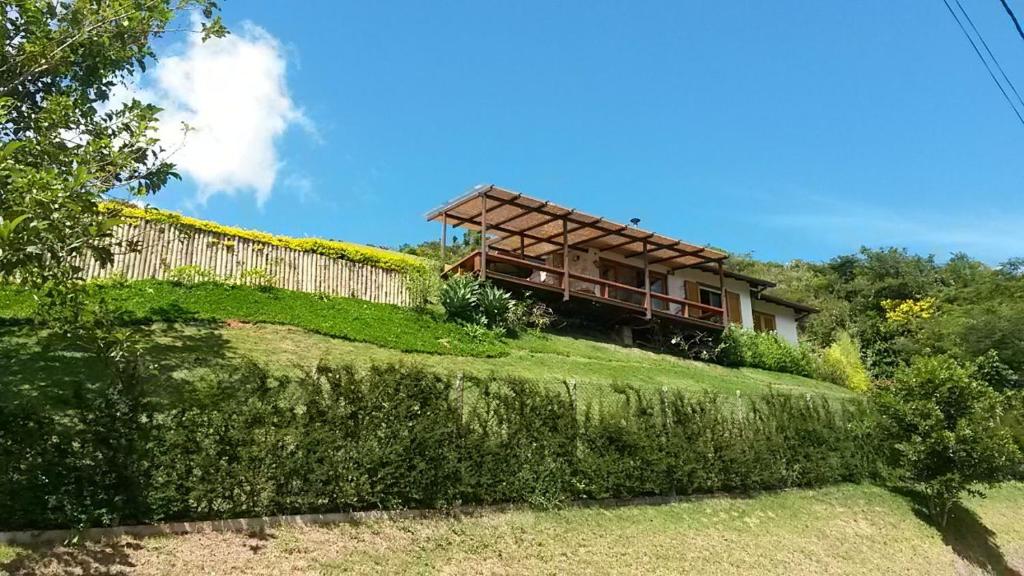 ein Haus auf einem Hügel mit einem Zaun in der Unterkunft Chalé da Manga Larga in Itaipava