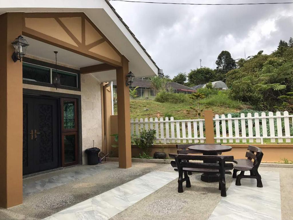 a patio with a table and chairs and a fence at Golden Hill in Cameron Highlands