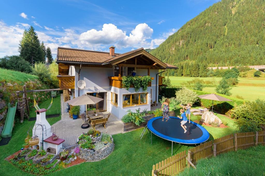 a house with two children playing on a trampoline at Helis Appartements in Flachau