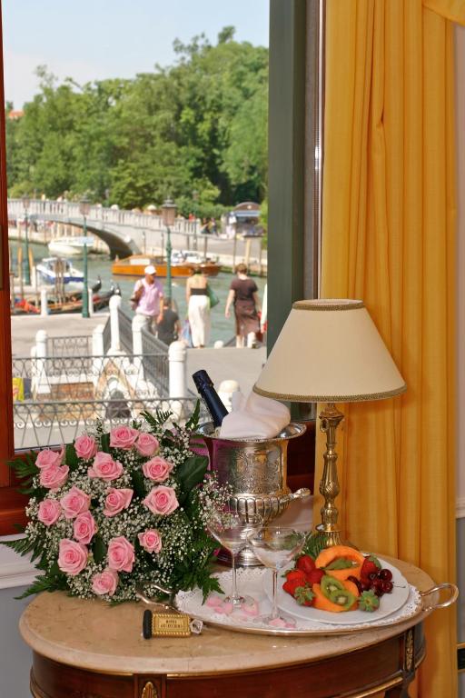 a table with flowers and a lamp on a table with a table sidx sidx at Hotel Arlecchino in Venice