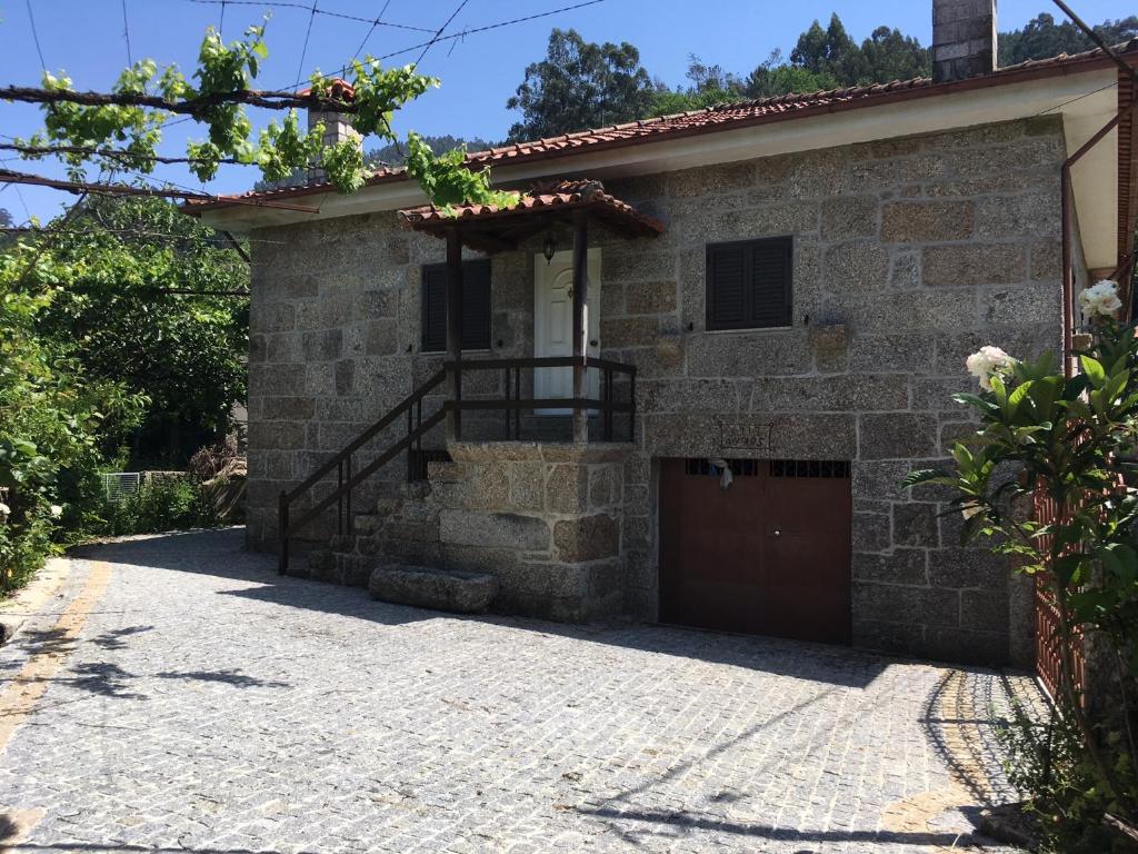 una casa de piedra con una puerta y un garaje en Casa dos Patricios en Terras de Bouro