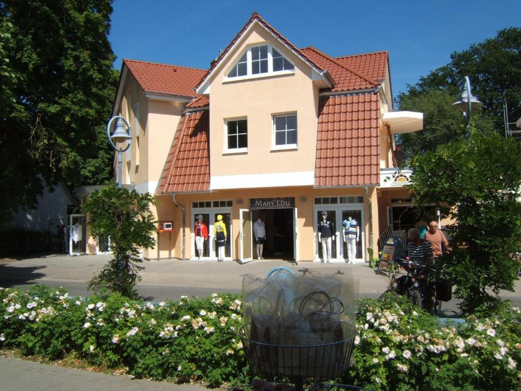 ツィングストにあるZingst-2-Zi-Ferienwohnung-Seewolfの目の前に人が立つ建物