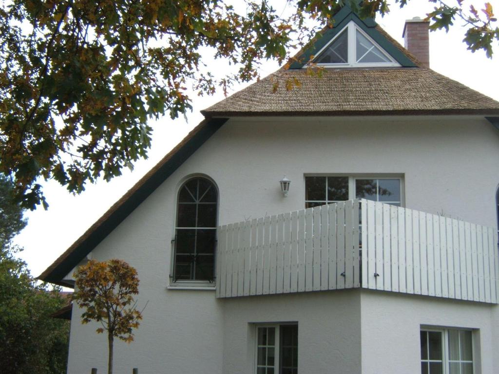 ツィングストにあるZingst-3-Zi-Ferienwohnung-DEICHIDYLL-Strandresidenz-Godeke-Michelsの急な屋根と窓のある白い家