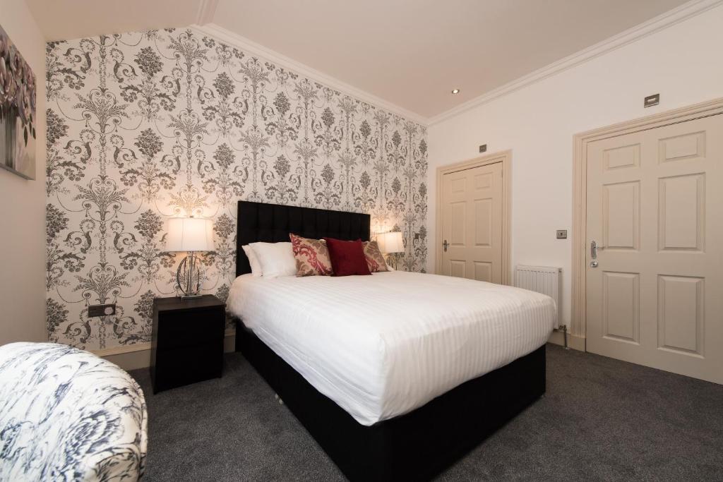 een slaapkamer met een groot wit bed en behang bij Royal Princes Suites in Edinburgh