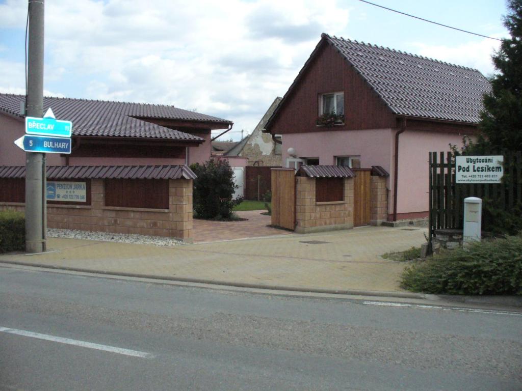 una casa al lado de una calle con un cartel en Penzion Jarka, en Lednice