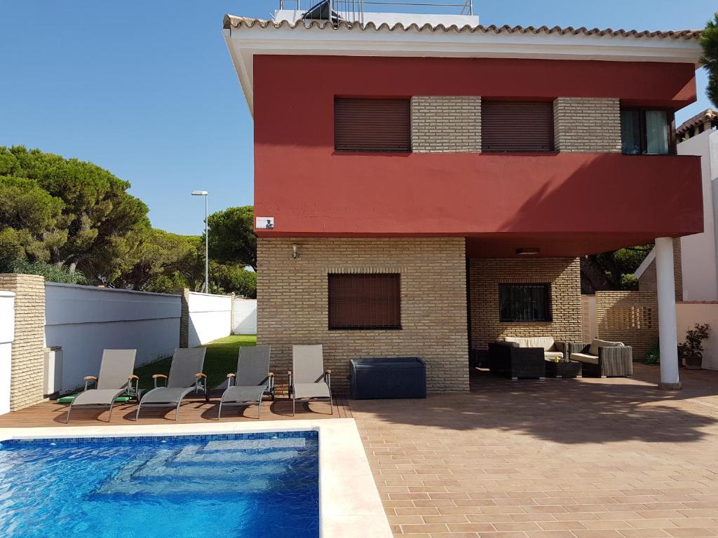a house with a swimming pool next to a building at Chalet Nora in Chiclana de la Frontera