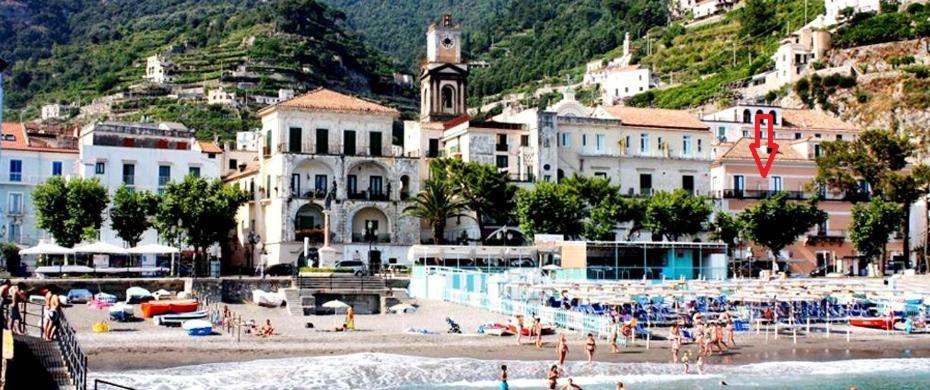 a group of people on a beach with buildings at Il Sagrato - Ravello Accommodation in Minori