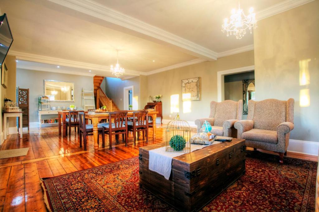uma sala de estar com uma mesa e uma sala de jantar em 23 On Glen Guest House em Port Elizabeth