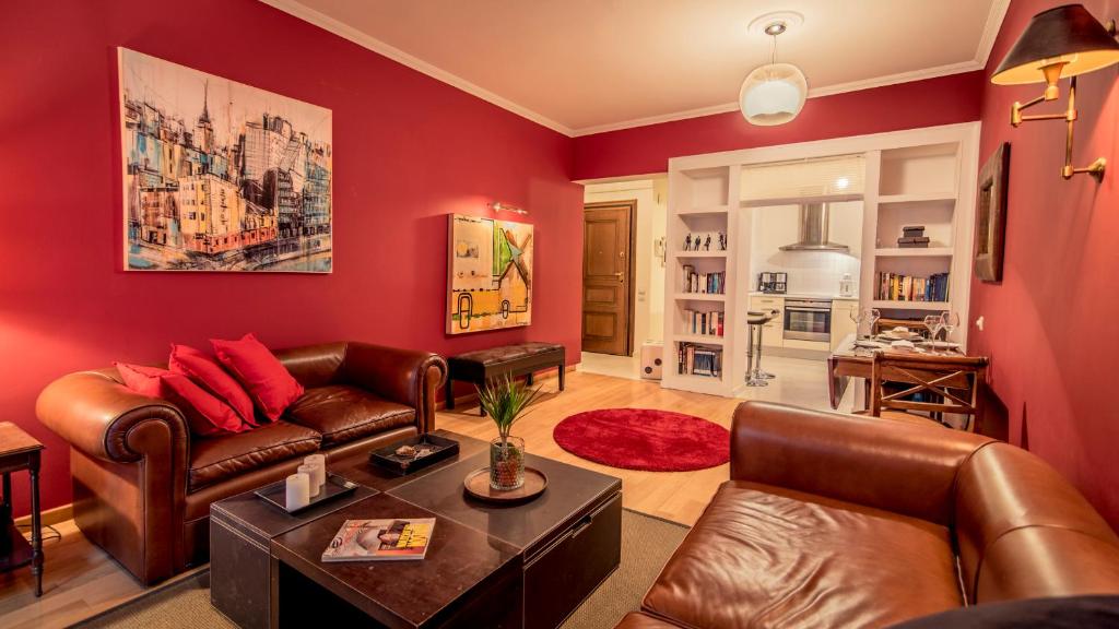 Elegant Supercentral Apartment في سلانيك: غرفة معيشة بجدران حمراء وأثاث من الجلد