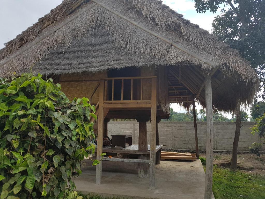 a hut with a roof with a bench in it at Rinjani Family Homestay in Sembalun Lawang