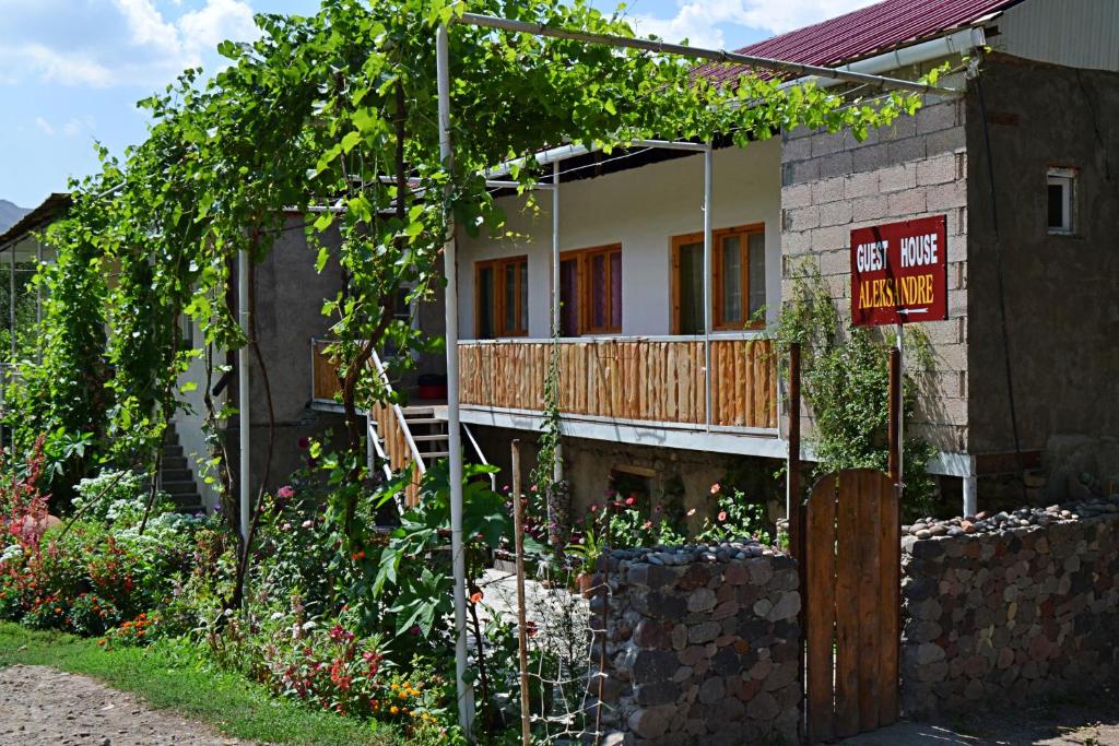 una casa con un cartel delante de ella en Guest House Aleksandre en T'mogvi