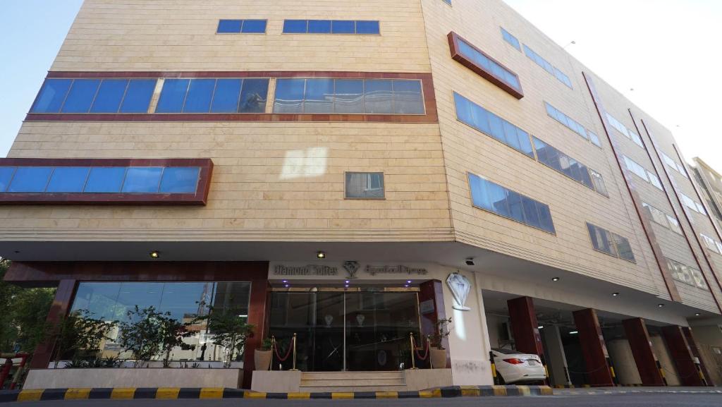 a tall building with a car parked in front of it at Jowharet AlMaseya in Al Khobar