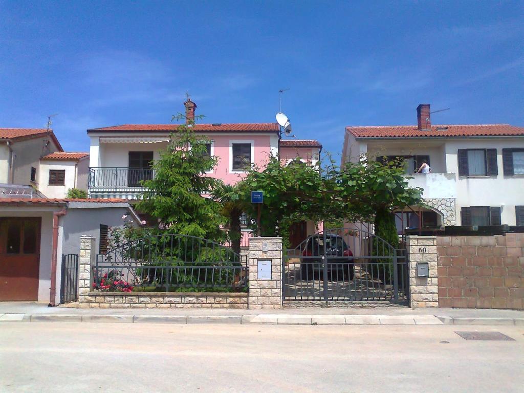 una casa rosa con una recinzione di fronte di Marija a Fažana