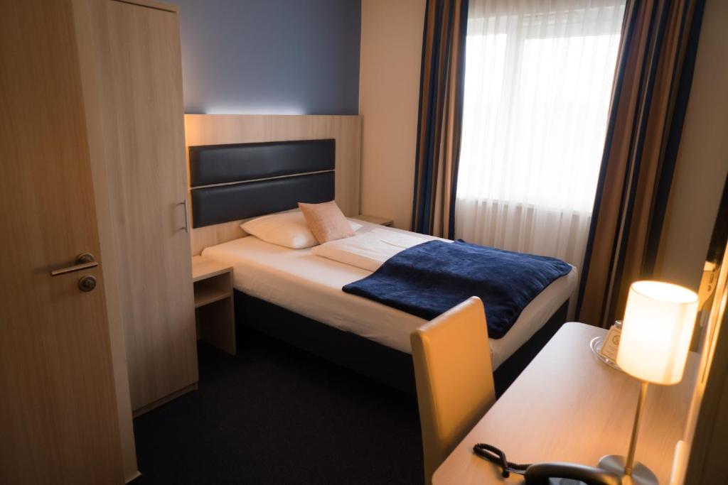 Postel nebo postele na pokoji v ubytování Hotel Rödelheimer Hof - Am Wasserturm