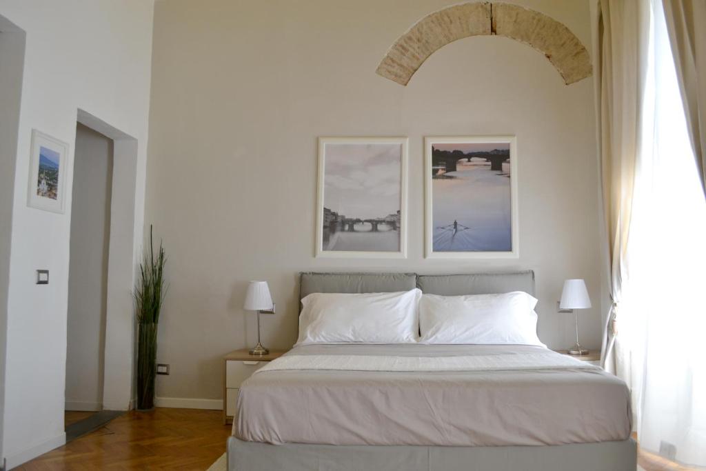 a bedroom with a bed with two lamps and a window at Domus Duomo in Florence