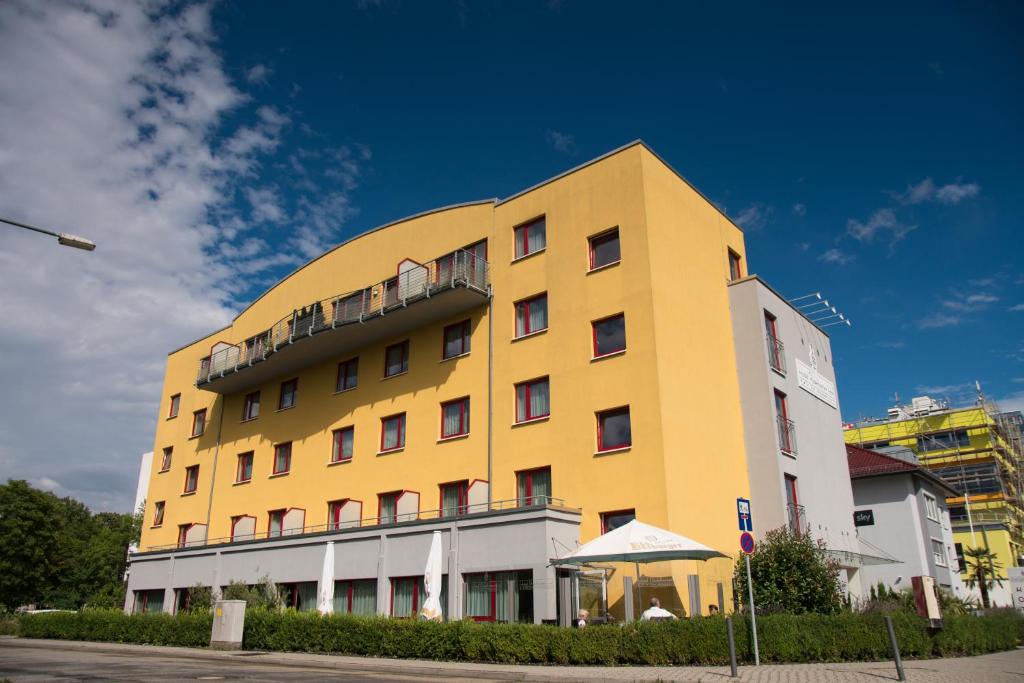 a yellow and white building with a blue at Hotel Rödelheimer Hof - Am Wasserturm in Frankfurt