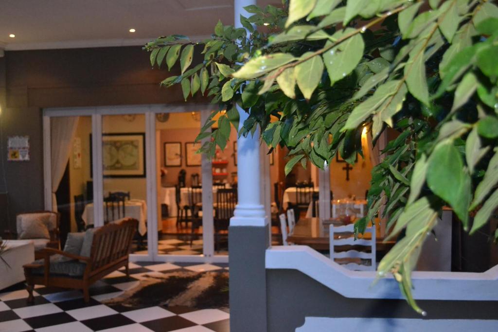 - un hall avec une table, des chaises et une plante dans l'établissement Convent Hill Lodge, à Ladysmith