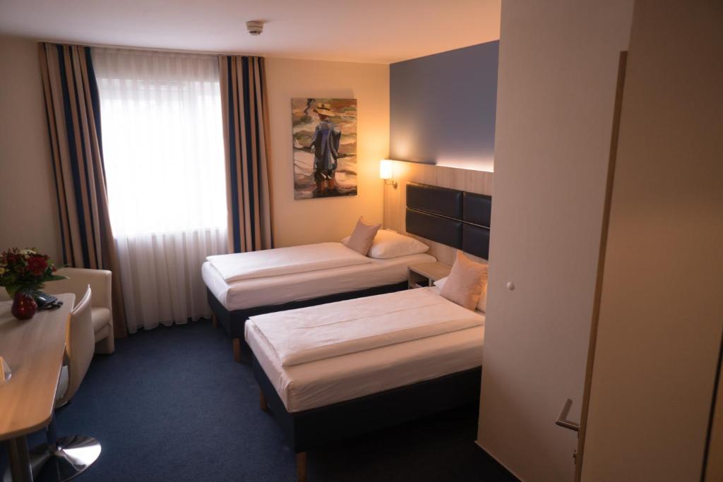 Postel nebo postele na pokoji v ubytování Hotel Rödelheimer Hof - Am Wasserturm
