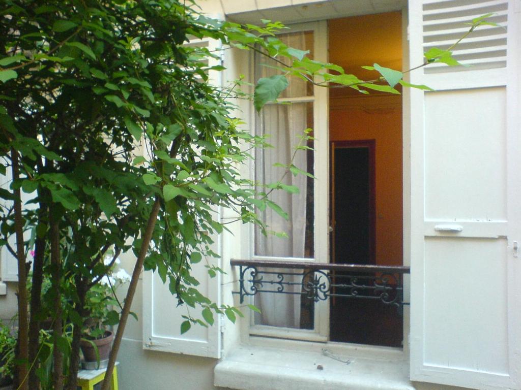 une porte ouverte d'une maison avec un balcon dans l'établissement Studio Paris tour Eiffel, à Paris