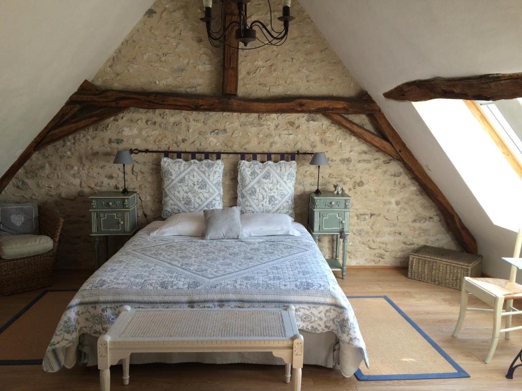 a bedroom with a bed in a attic at La Bihourderie in Azay-sur-Indre