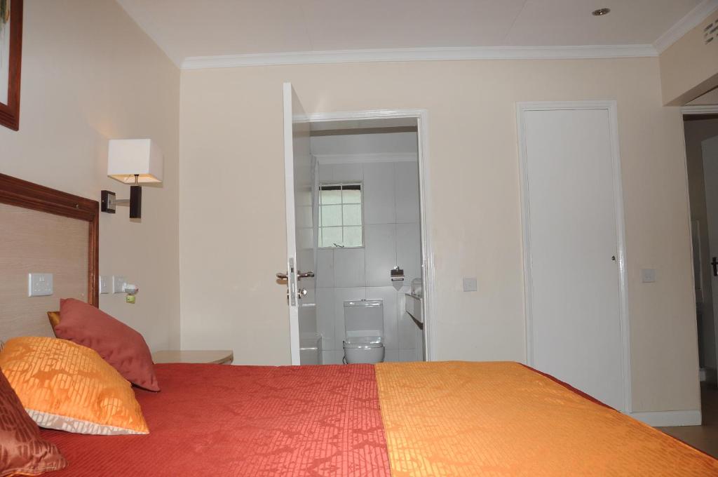 1 dormitorio con 1 cama y baño con aseo en Hotel Riverview Westlands, en Nairobi